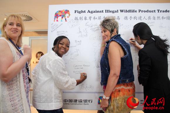 9月23日，南非中资企业员工响应“抵制象牙和犀牛角贸易，携手构建人类自然和谐”签名倡议。图为中国建设银行约翰内斯堡分行本地员工签字。人民网 张洁娴 摄