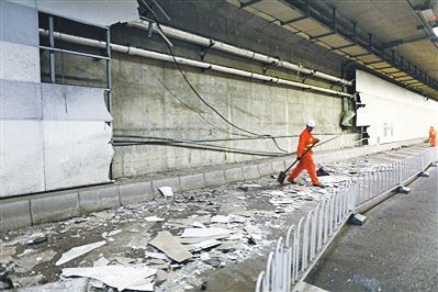 大屯路隧道内，北侧约70平米墙皮被剐蹭掉，救援人员正在清理。网络图/L