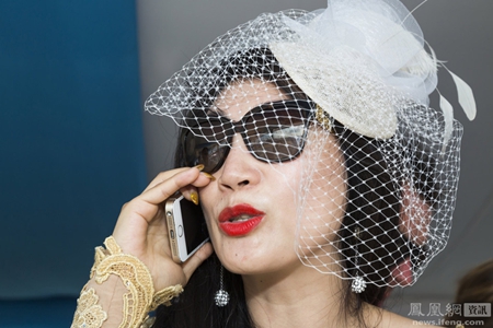 海滩马球世界杯冠军赛上，Siyu Yang正在用金色苹果手机通话。