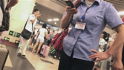 7月4日，北京西站A2出口，一名“医托”胸口挂着“北京西站工作证”。
