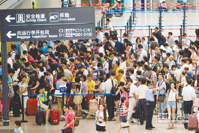 两岸春节加班机明天上午8时开卖。图为旅客去年春节期间在上海虹桥机场排队换票。（台媒取自新华社）