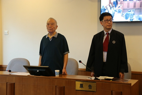  一审时，季承（左）在法庭上。北京一中院供图