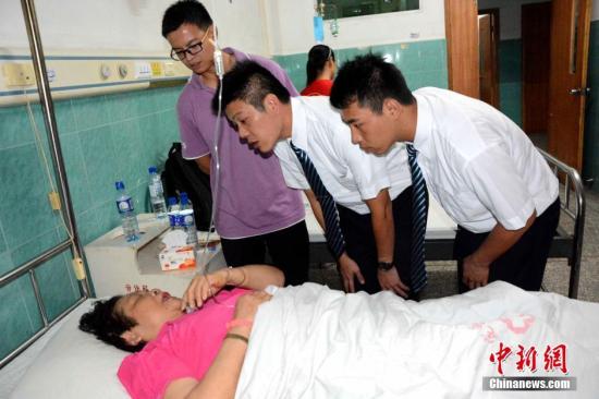 8月13日上午，一辆载有21名台湾游客的旅游大巴在前往福建省龙岩市永定区湖坑镇附近突遇山体滑坡引发的道路塌方，导致车辆被冲翻，1人罹难、2人重伤、其他游客轻伤。经当地消防部门和附近居民第一时间全力抢救，伤员被及时送往当地医院接受救治，均无生命危险。事故发生后，国台办、国家旅游局等有关部门高度重视，指导有关方面做好善后。福建省迅即启动突发事件应急处理机制，成立事故处理小组并派专人赶赴事故现场，全力开展善后工作。图为台湾义工到医院询问伤者情况和做好安抚工作。 <a target='_blank' href='http://www.chinanews.com/'><p  align=