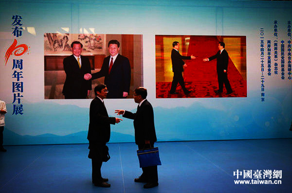 4月25日，“两岸和平发展共同愿景”发布10周年图片展在南京举办。图为2位参观者在现场谈论交流
